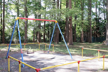 公園のブランコと緑の森、子供の遊び場の風景