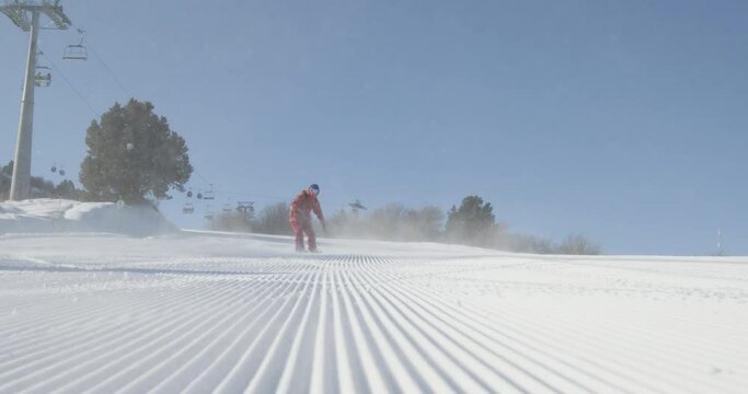 Busy ski slope full of snowboarders. Professional energetic enthusiastic snowboarders athletes slide down specially designated safe velvet ski slope, having fun together. Snowflakes fly into camera.