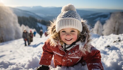 Fototapeta na wymiar Happy child having fun on fresh snow on beautiful winter day in mountains