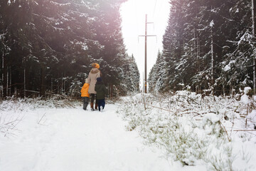Happy family playing and laughing in winter outdoors in the snow. City park winter day.
