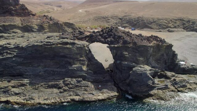 Fuerteventura Island, Ajui: aerial view from the sea traveling in over the Jurado arch on a sunny day with beautiful colors and turquoise ocean.