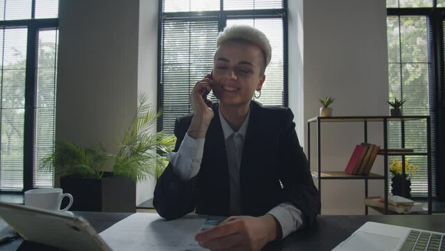 Young pleasant caucasian businesswoman chat with boyfriend using mobile phone. Student woman employee talking to friends via smartphone in office. Call center worker girl answering