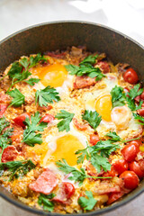 Shakshouka for breakfast. Homemade shakshuka, fried eggs, onion, bell pepper, tomatoes and parsley in a pan. Marble background. Top view. chakchouka