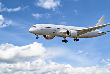 Fototapeta na wymiar Boeing 787-8 Dreamliner passenger plane landing at the airport, under a blue sky with white clouds
