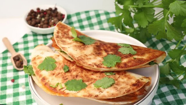 Quesabirria tacos is a Mexican dish that consists of spicy, shredded beef and melted cheese, fresh cilantro, enclosed in tortillas,  rotation in circle. a plate of tacos, Turning