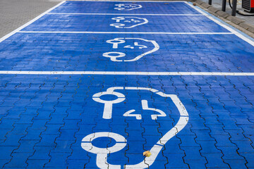 he car park is marked for parking and refuelling of electric cars and the road is painted blue. 