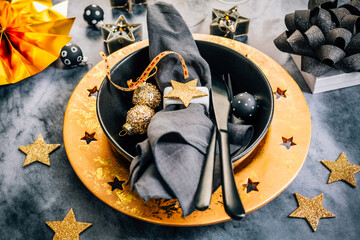 Place setting in golden and black tone for Christmas, New Year