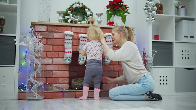 A young child drops Christmas tree lights on the floor, with which the fireplace was decorated.
