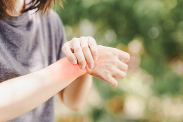 A woman squeezes a wrist that is inflamed due to arthritis or an accident that resulted in a sprain. - obrazy, fototapety, plakaty