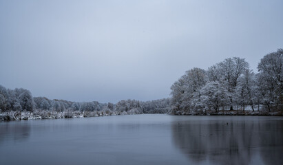 Frozen lake in northern German countryside after snowfall in winter