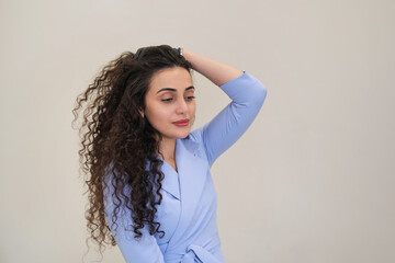 Naklejka premium A graceful Egyptian beauty is seen tending to her luxurious curly mane with gloved fingers. The right hair treatment can transform one's appearance.