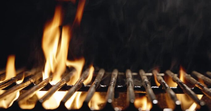 Grill in the kitchen of the restaurant or outdoors nature, the flame seeps through the grill.Hellish barbecue. Hearth in the fireplace, Glowing Coal and Fire Sparks, copy space for fire title 