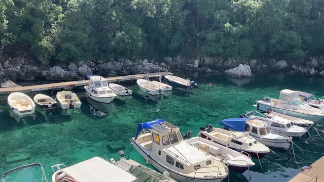 Small bay in Zagorje Brestova, seen from the ferry to get to Cres, white-rigged boats twinkle under a bright August sun