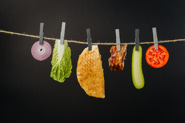 Doner kebab with ingredients hanging on a thread in the air : beef meat, lettuce, onion, tomatoes,...