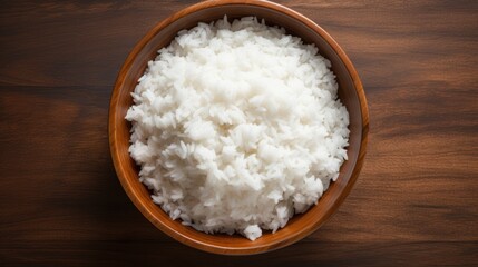 Fototapeta na wymiar A wooden plate filled with fluffy white rice sits on a table, ready to be served