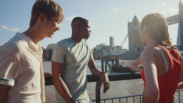 Group of teenagers friends spending time in the main areas of London as the tower bridge. Concept about generation z and friendship
