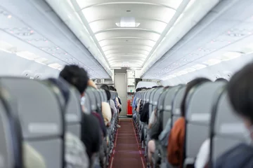 Fotobehang A compact aisle and snug seating within the budget airline cabin, entirely occupied by passengers of Asian descent, prepared for departure. © Surachetsh