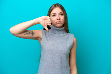 Young Lithuanian woman isolated on blue background showing thumb down with negative expression