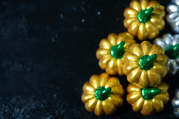 Pumpkins made from stucco, silver and golden yellow. Placed on a black, rough background