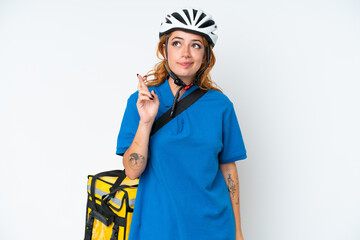 Young caucasian woman with thermal backpack isolated on white background with fingers crossing and wishing the best