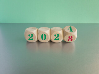 Flipping of 2023 to 2024 on wooden cube for preparation merry Christmas and happy new year change...
