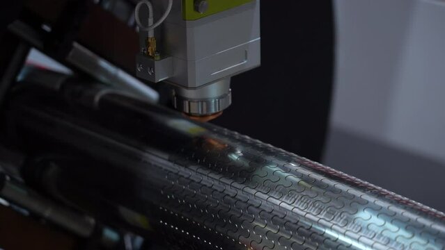 CNC laser cutting machine cuts uniform wavy lines pattern in a stainless steel pipe