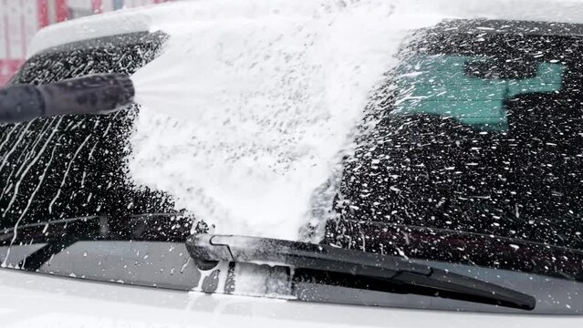 Driver washes car at self-service car wash, applies foam to rear window
