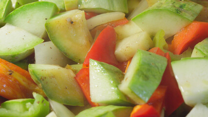 Roasting vegetarian dish of zucchini and sweet peppers in pan.