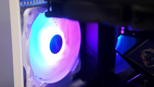 The fan rotates slowly in the case. An integral part of a computer, a spinning cooling fan. Computer equipment, part, assembly and repair, IT