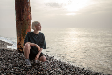 Outdoor portrait of young blonde woman with short bob hairstyle on sea beach