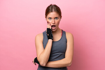 Young sport caucasian woman isolated on pink background surprised and shocked while looking right