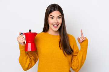 Young Brazilian woman holding coffee pot isolated on white background pointing up a great idea