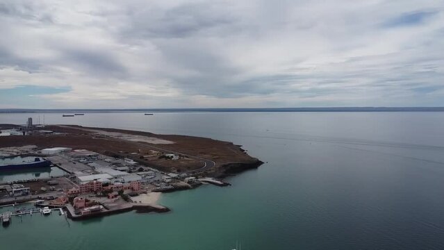 Aerial panorama view of the beautiful Playa Pichilingue near Pichilingue port of La paz in Baja California, Sur Mexico with calm sea and rocky landscape with cloudy sky