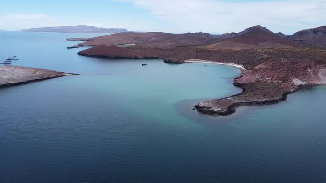 Aerial wide panorama view of the beautiful Playa Pichilingue near La paz in Baja California Sur Mexico with blue sea with floating ships and rocky landscape with mountains in background
