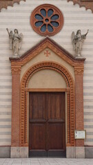 Fototapeta na wymiar The entrance of the catholic church Parrocchia Santi Nazzaro e Celso in Sannazzaro de Burgondi, Italy, in the month of May