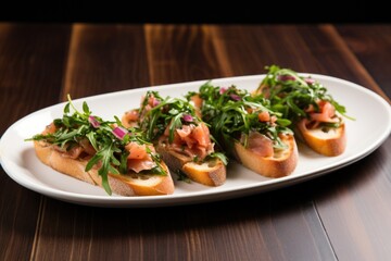 ceramic plate of bruschetta with chopped arugula and red onion