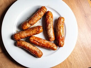 Pork Sausage on a white plate a closeup of a number of cooked meaty sausage