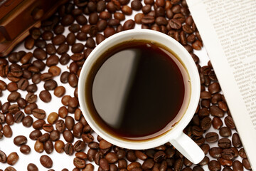 Black coffee and coffee beans on newspaper