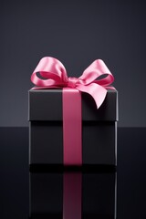 Gift box, bow and ribbon on black background.