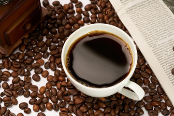 Obraz na płótnie Canvas Black coffee and coffee beans on newspaper