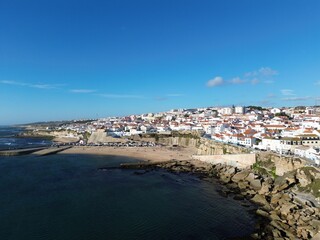 Fototapeta na wymiar a beach and sea next to a small town with houses