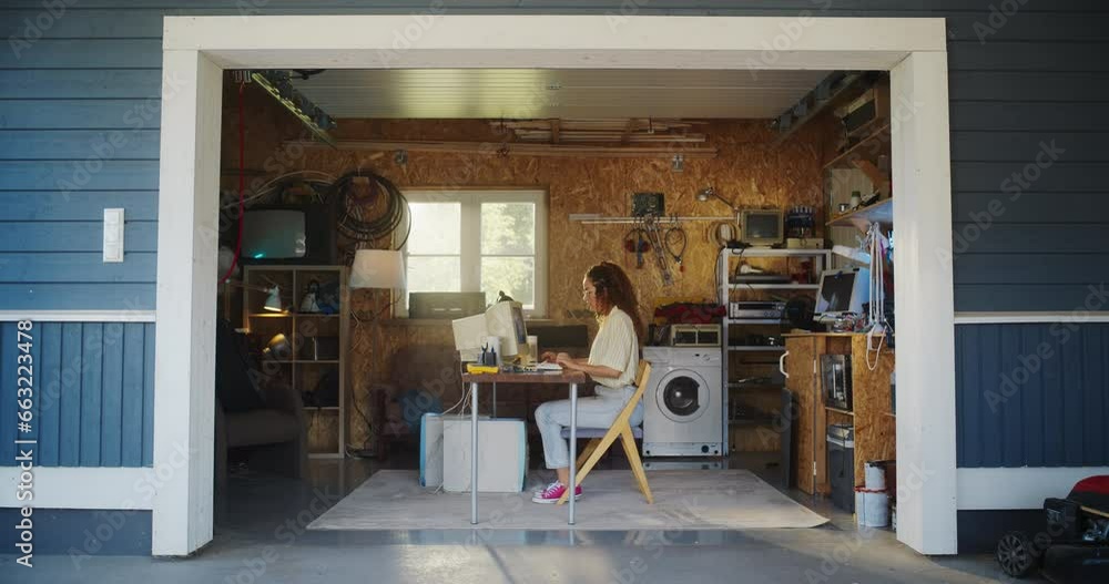 Poster Hispanic Female Developer Programming On Old Desktop Computer In Retro Garage With Random Appliances. Young Woman Working On Innovative Online Service Startup Company In Nineties. Nostalgia Concept.