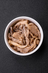 Delicious spicy mushrooms sliced and cooked in Korean style on a ceramic plate
