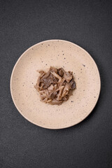 Delicious spicy mushrooms sliced and cooked in Korean style on a ceramic plate