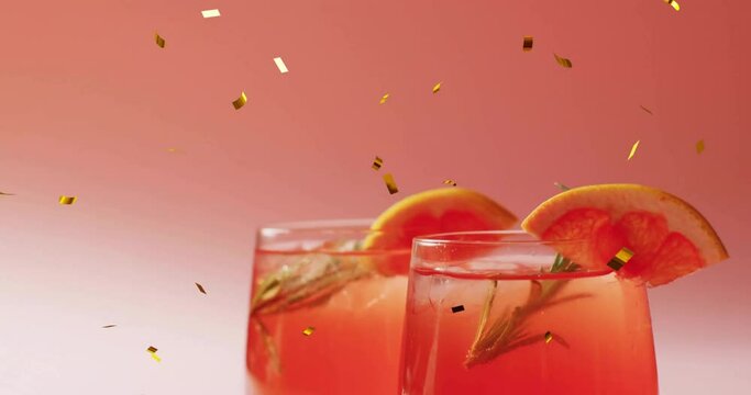 Animation of confetti falling and cocktail on pink background