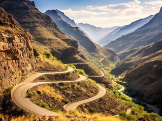 A picturesque road gracefully snakes through a secluded canyon surrounded by towering rock formations.