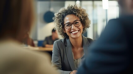 Happy African American mature middle 60s aged smiling lady boss manager talking to colleagues meeting in office space. Team leader portrait of company team working together in modern office. Closeup - obrazy, fototapety, plakaty