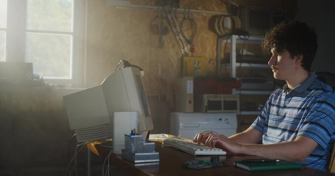 Caucasian Male Software Engineer Programming On Old Desktop Computer In Retro Garage. Enthusiast Browsing Early Internet Forums, Coding Applications, Chatting Online In Nineties. Nostalgia Concept.