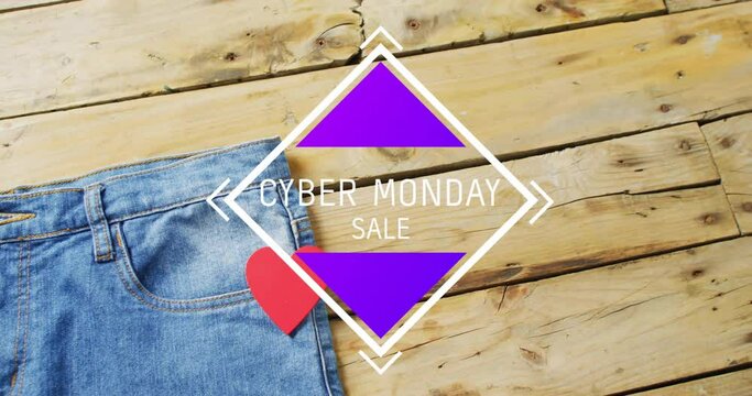 Animation of cyber monda sale text over denim trousers on wooden background
