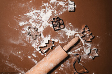 Preparing Christmas Cookies. Shapes of Christmas cookie and rolling pin with scattered flour on the table.